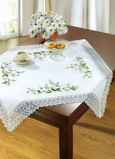 Raumdekoration mit Gänseblümchen-Stickerei und zarter Häkelspitze 